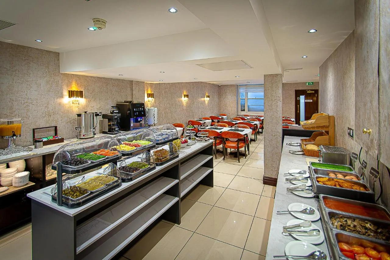 a buffet line in a restaurant with many plates of food at Hyde Park International in Bayswater, London