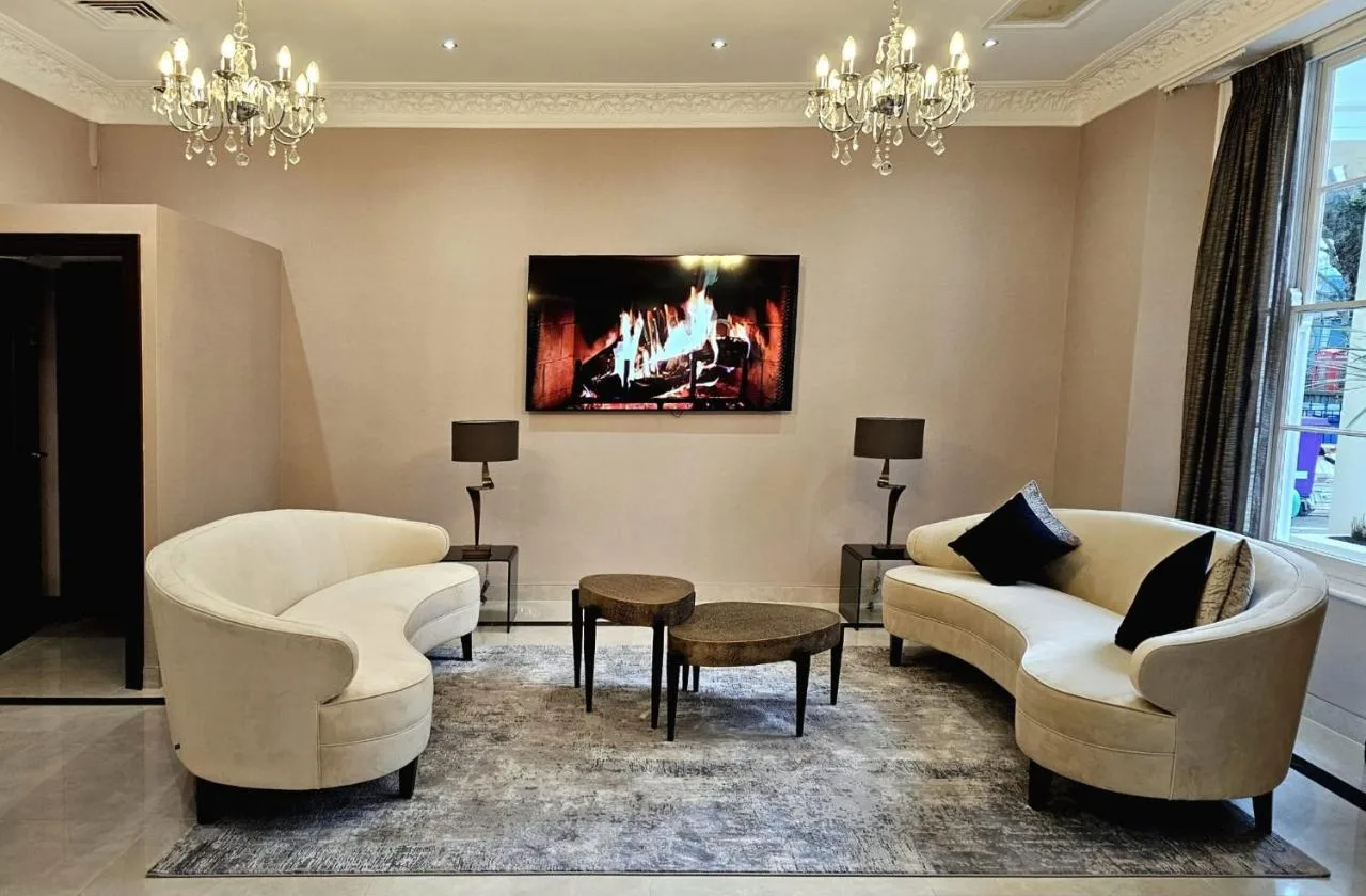 a living room with two chairs and a fireplace at Hyde Park International near Hyde Park, London