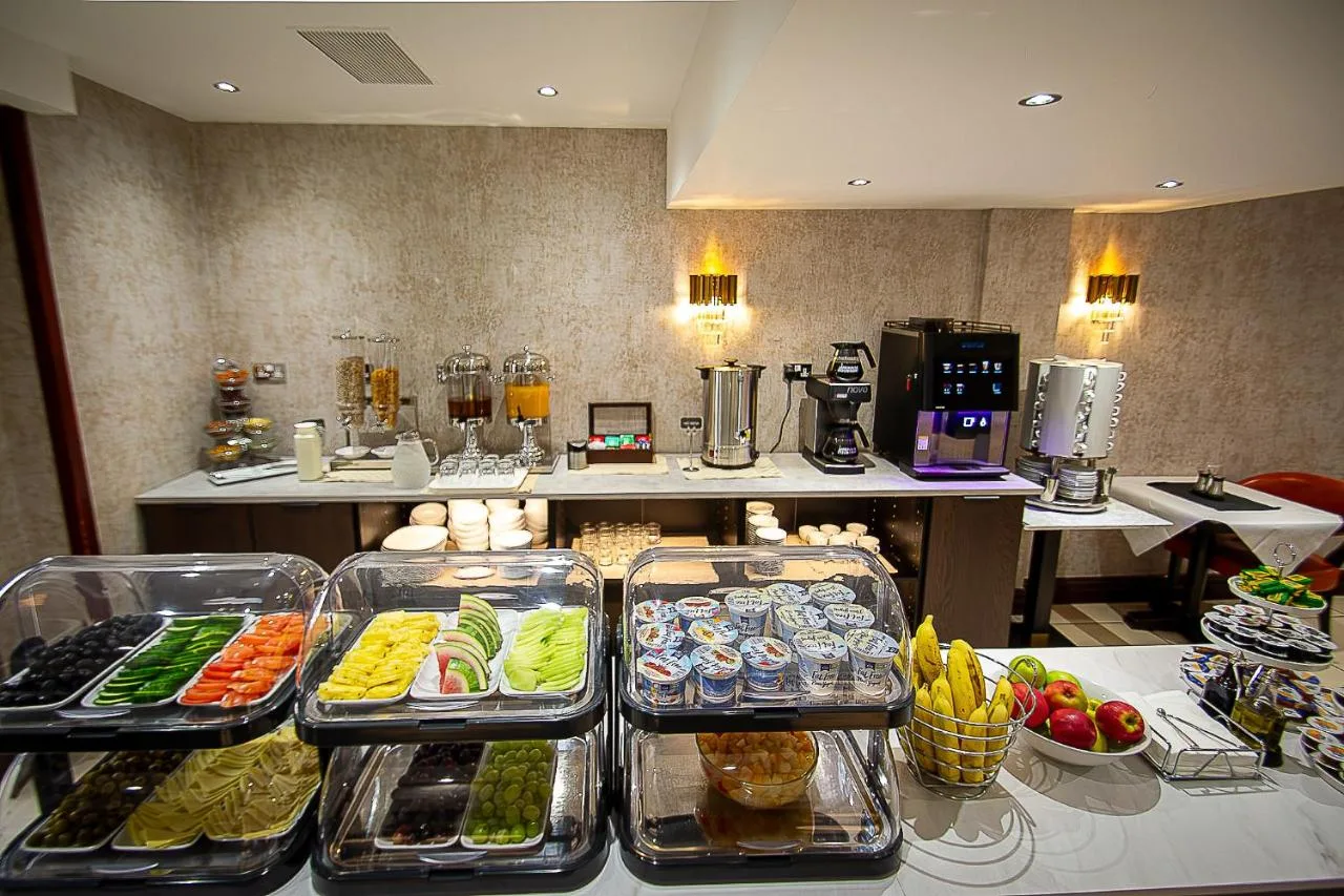 a kitchen with several trays of food on a table at Hyde Park International, London