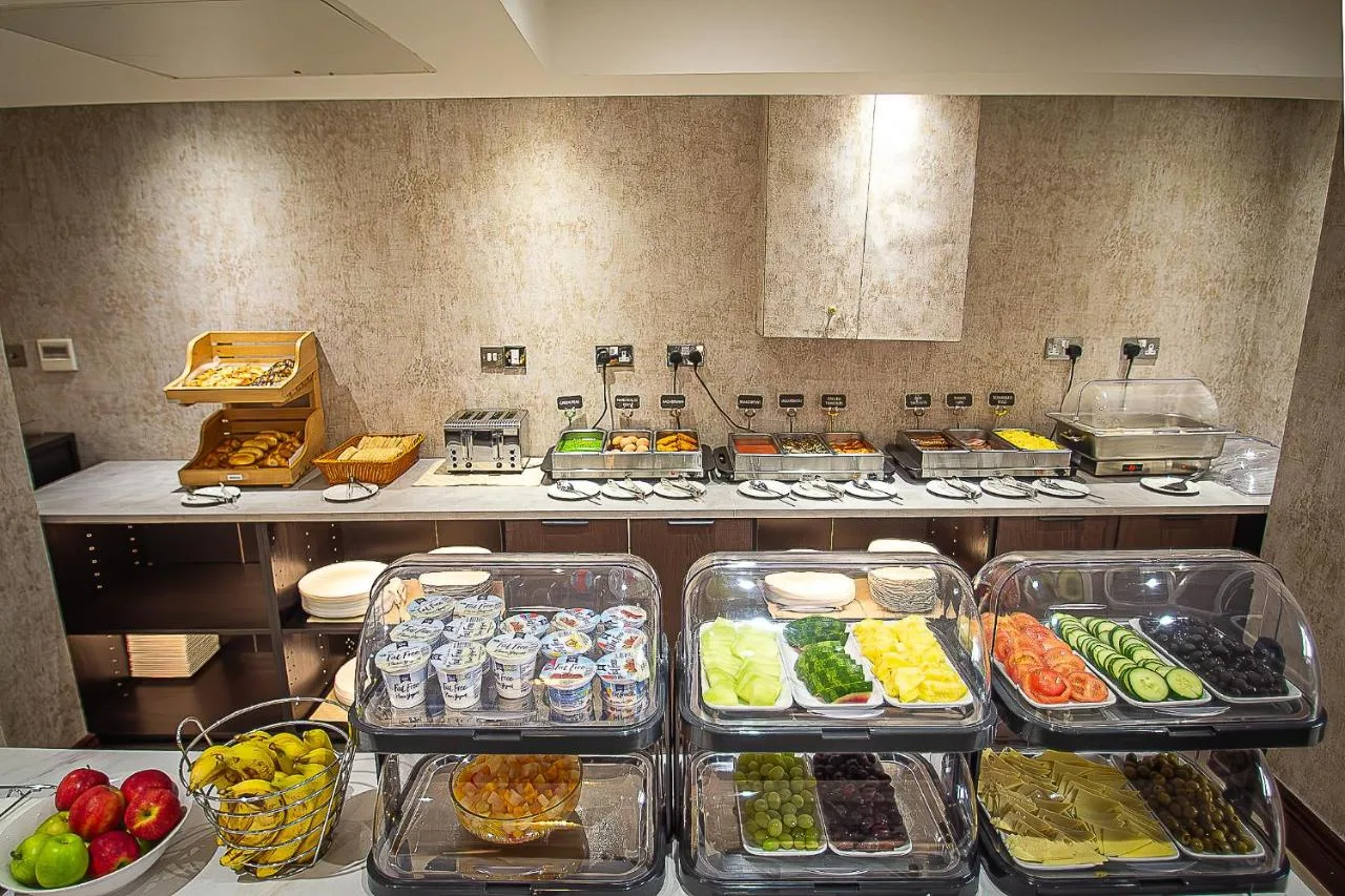 a kitchen with many trays of food on a counter at Hyde Park International near Paddington