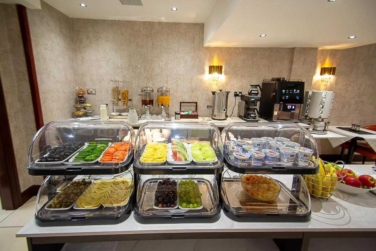 a buffet with several trays of food on a counter at Hyde Park International, London W2